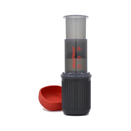 AeroPress Go portable coffee maker with black textured body and red cup for travel brewing