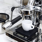 Brewista Smart Scale II placed under espresso machine with white coffee cup on top